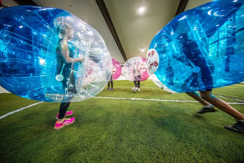 Sechs Menschen spielen Bubblesoccer in einer Indoor Arena