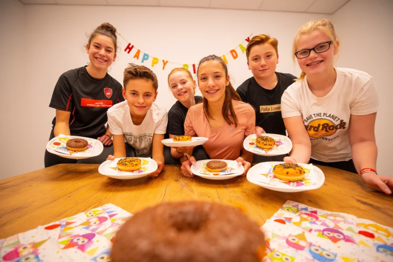 Sechs Kinder während einer Geburtstagsfeier mit Kuchen